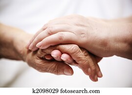 adult helping senior in hospital