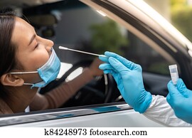 Asian woman Drive Thru COVID-19 testing with PPE medical staff Asian woman Drive Thru COVID-19 testing with PPE medical staff