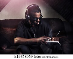 dj writing lyrics on note book in studio dj writing lyrics on note book in studio