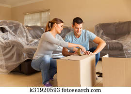 couple sealing moving boxes couple sealing moving boxes