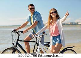 happy young couple riding bicycles at seaside happy young couple riding bicycles at seaside