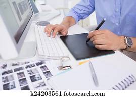 Graphic designer using digitizer at his desk Graphic designer using digitizer at his desk