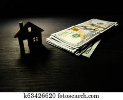 Model of home and money in the dark. Mortgage or dollars for rent concept. Model of home and money in the dark. Mortgage or dollars for rent concept.