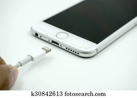 close up image of the new apple iphone 6s with the charging cabl close up image of the new apple iphone 6s with the charging cabl