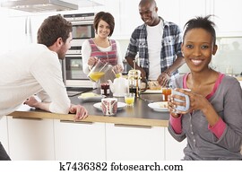 Group Of Young Friends Preparing Breakfast In Modern Kitchen