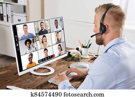 Businessman Video Conferencing With Team On Computer Businessman Video Conferencing With Team On Computer