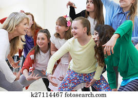 Group Of Children With Teacher Enjoying Drama Class Together