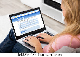 Woman Giving Online Survey On Laptop Woman Giving Online Survey On Laptop