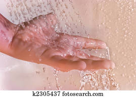 Children's hand under the shower washing