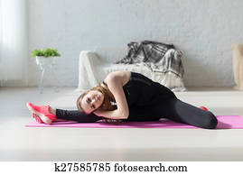 Fit woman high body flexibility stretching her leg and back to warm up doing aerobics gymnastics exercises at home