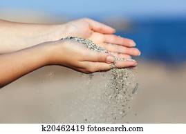 A woman with sand falling through her hands