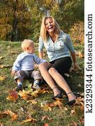 blue-eyed blond sits with the son in the park in autumn 2 blue-eyed blond sits with the son in the park in autumn 2
