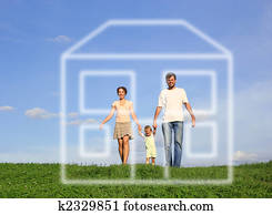 family with baby walking on grass and dream house