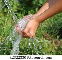 Hands catching clean falling water close up