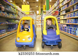 children in the toy automobiles in the store