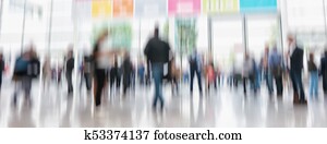 defocused business people walking in trade show hall defocused business people walking in trade show hall