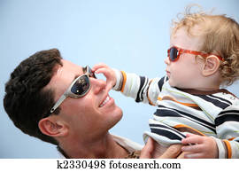 father with the child in the sunglasses against the background of the sky
