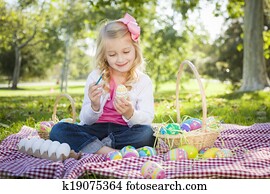 Cute Young Girl Coloring Her Easter Eggs with Paint Brush