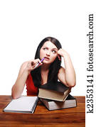 Confused girl sitting at desk with writing pad