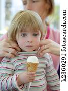 Beautiful toddler eating ice cream, mother care