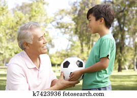 Grandfather And grandson In Park With Football