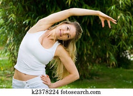 Blonde girl in park doing yoga