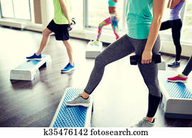 group of people with dumbbells and steppers group of people with dumbbells and steppers