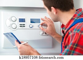 Technician servicing heating boiler Technician servicing heating boiler