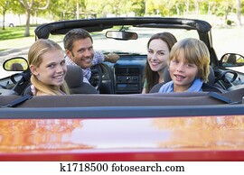 Family in convertible car smiling