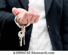 A real estate agent holding keys to a new house in her hands.