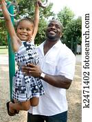 A father helps his daughter on the playground A father helps his daughter on the playground