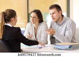 Couple claiming to a businesswoman at office Couple claiming to a businesswoman at office