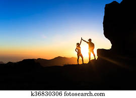 Teamwork couple climbing helping hand Teamwork couple climbing helping hand