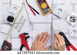 Architect Drawing Plan On Blueprint With Electrical Components