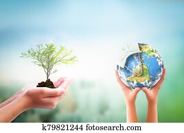 Earth Day concept: hands holding Corona virus or COVID-19 Earth globe wearing a mask and tree over nature background. Elements of this image furnished by NASA Earth Day concept: hands holding Corona virus or COVID-19 Earth globe wearing a mask and tree over nature background. Elements of this image furnished by NASA