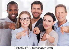 We choose you! Group of cheerful business people in casual wear standing close to each other and pointing you