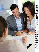 Young couple signing financial contract