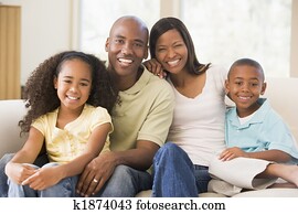 Family sitting in living room smiling