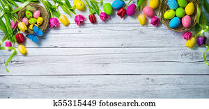 Easter background. Colorful spring tulips with butterflies and painted eggs