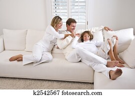 Family relaxing at home on white living room sofa Family relaxing at home on white living room sofa