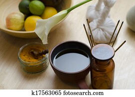A countertop arrangement of ayurvedic turmeric spice, oil and massaging tools and an exotic flower used in Ayurveda massage.