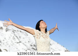 Happy woman breathing deep raising arms in winter Happy woman breathing deep raising arms in winter
