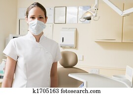 Dental assistant in exam room with mask on Dental assistant in exam room with mask on