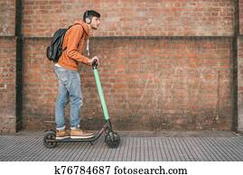 Young man driving electric scooter. Young man driving electric scooter.