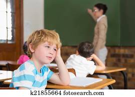 Cute pupil not paying attention in classroom