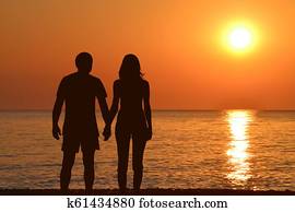 young couple, holding hands, watching, jeden, východ slnka, na, morský breh