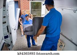 Happy Family Couple Watching Movers Unload Furniture Happy Family Couple Watching Movers Unload Furniture