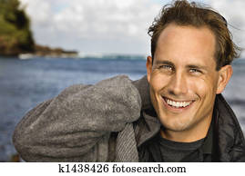 Man smiling by ocean.