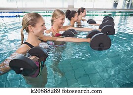 Smiling female fitness class doing Smiling female fitness class doing