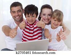 Family at home using a laptop with thumbs up Family at home using a laptop with thumbs up